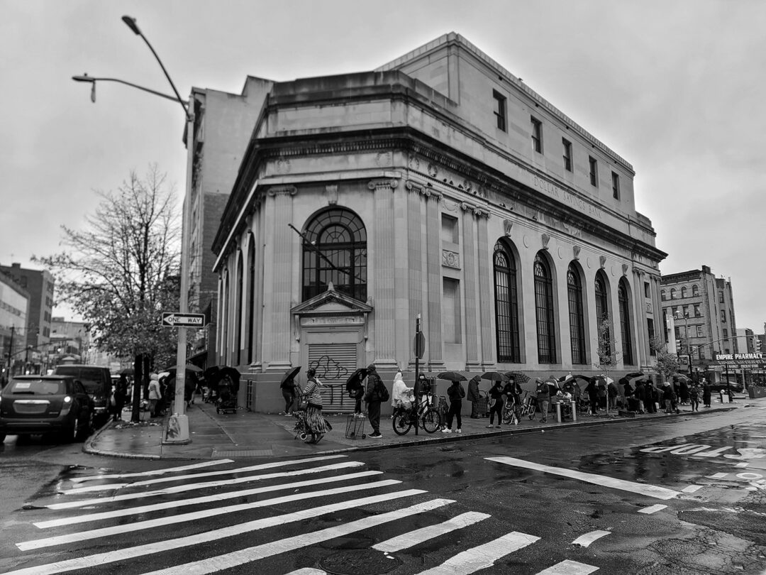 A line for the 7th Day Adventist Church food pantry stretches around the old Dollar Savings Bank at Third Avenue and 147th Street in Melrose in early days of COVID-19 pandemic. (Ed Garcia Conde)