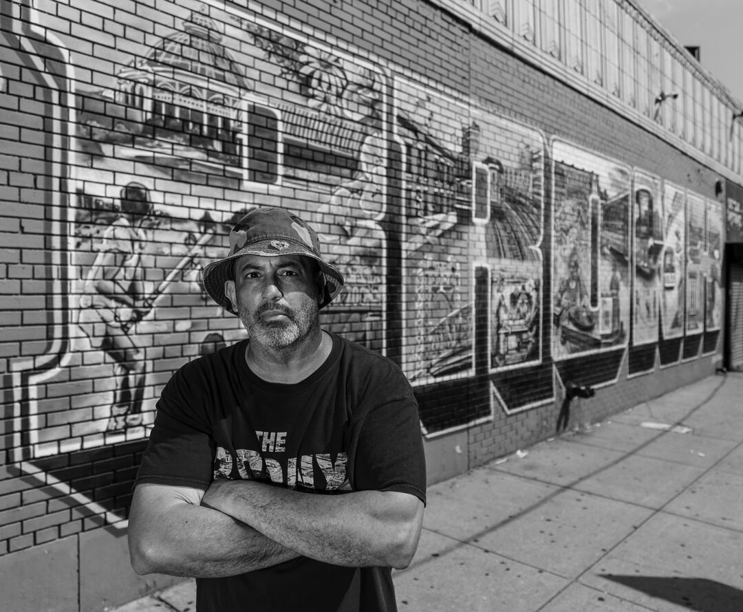 Bio of TATS Cru poses in front of one of the group’s many Bronx murals. (Michael Young)